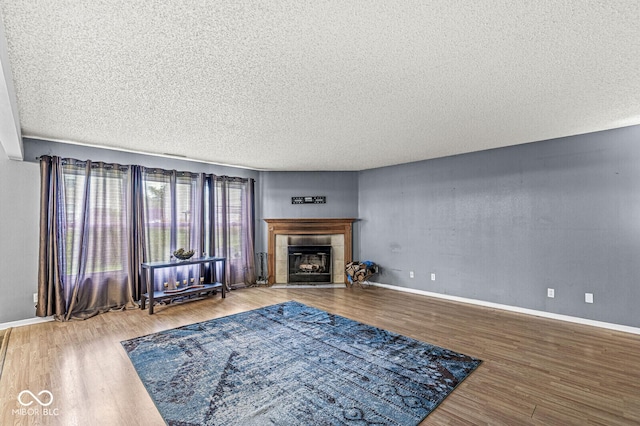 6259 Teacup Dr, Indianapolis, IN 46235 - living area with wood finished floors, a tiled fireplace, and a textured ceiling