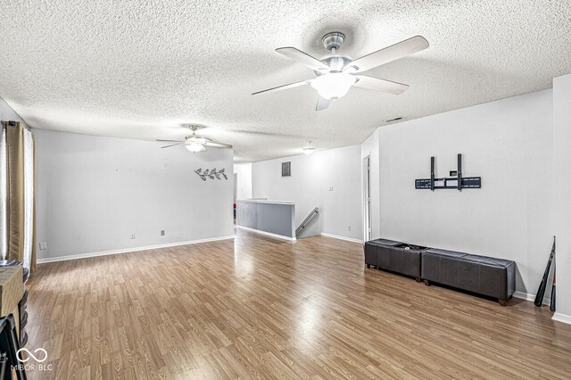 6259 Teacup Dr, Indianapolis, IN 46235 - unfurnished living room featuring ceiling fan, wood finished floors, and a textured ceiling