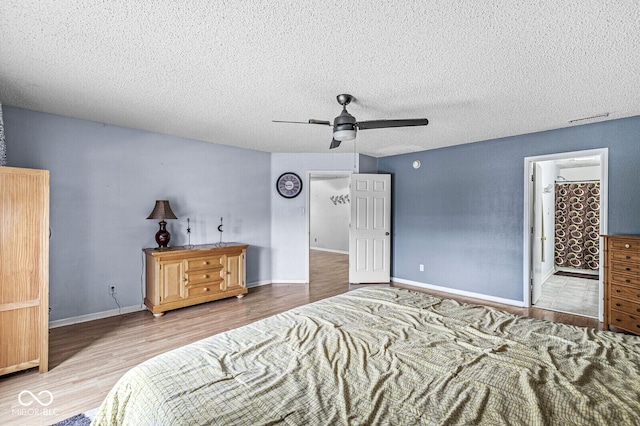 6259 Teacup Dr, Indianapolis, IN 46235 - bedroom with wood finished floors, a textured ceiling, a ceiling fan, and connected bathroom