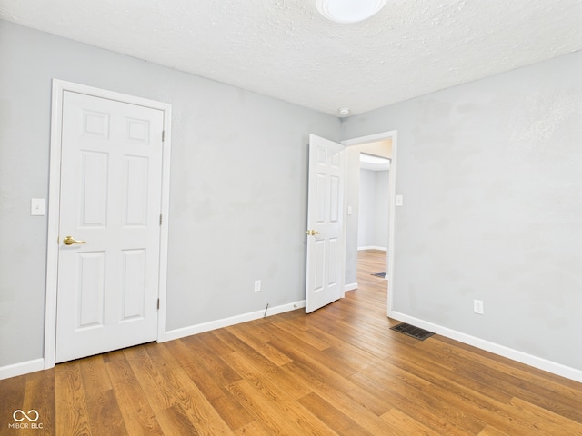 4025 Main St, Anderson, IN 46013 - unfurnished bedroom with light wood-style flooring and a textured ceiling