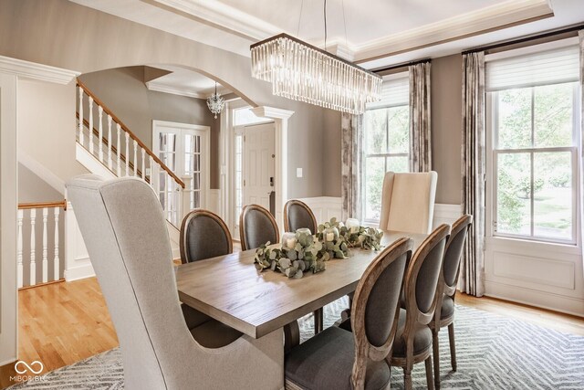 12505 Branford St, Carmel, IN 46032 - dining area featuring arched walkways, wood finished floors, crown molding, healthy amount of natural light, and wainscoting
