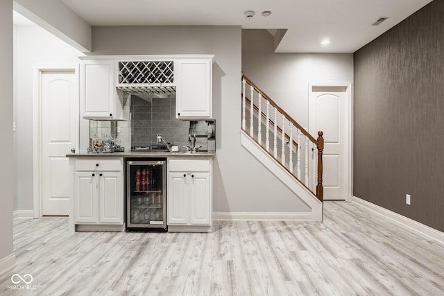 12505 Branford St, Carmel, IN 46032 - indoor wet bar featuring beverage cooler, light wood-type flooring, backsplash, stairs, and recessed lighting