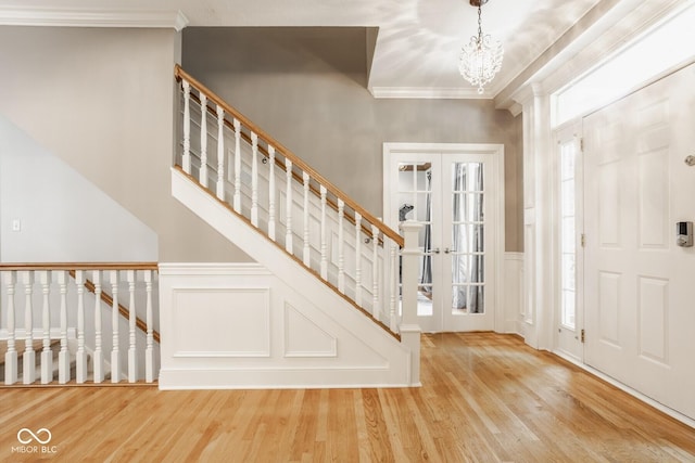 12505 Branford St, Carmel, IN 46032 - foyer featuring a decorative wall, wood finished floors, crown molding, a chandelier, and a wainscoted wall
