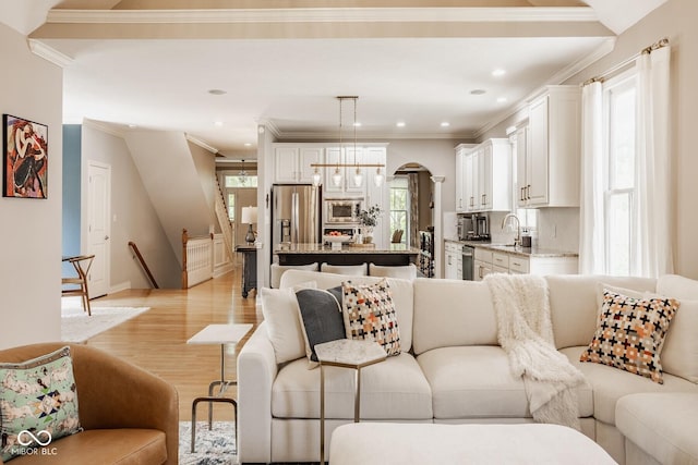 12505 Branford St, Carmel, IN 46032 - living area featuring plenty of natural light, light wood-style floors, ornamental molding, arched walkways, and recessed lighting