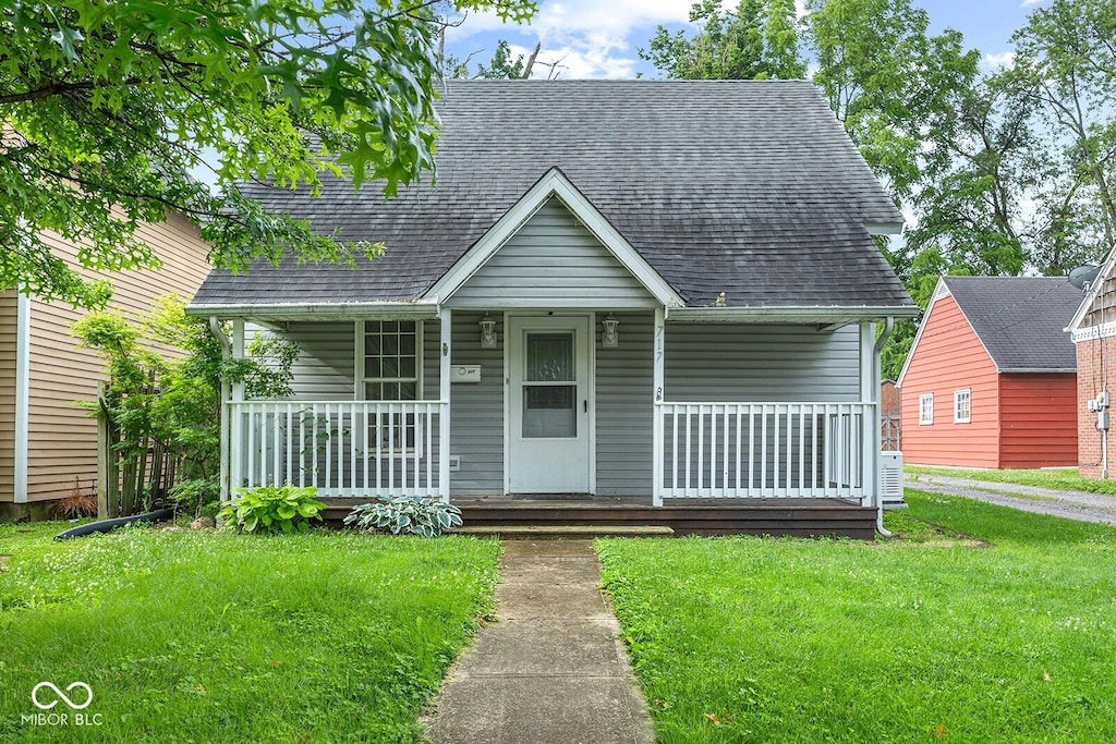 717 W Wabash Ave, Crawfordsville, IN 47933 - view of front of house featuring a front lawn, covered porch, and a shingled roof