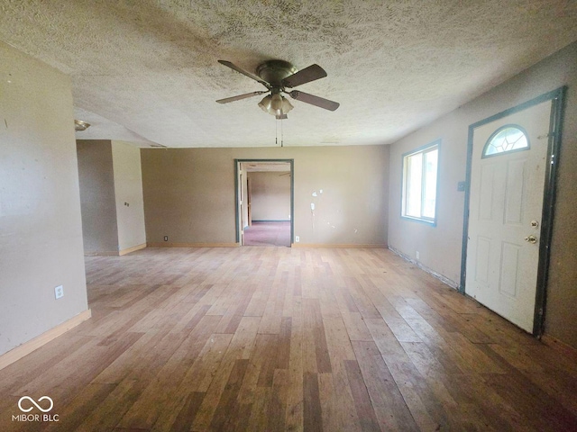 5156 N 14th St, Terre Haute, IN 47805 - unfurnished living room featuring a ceiling fan, light wood-type flooring, and a textured ceiling