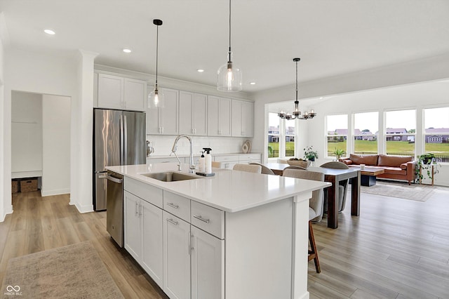 4250 Blackford Rd, Bargersville, IN 46106 - kitchen with light wood-style floors, stainless steel dishwasher, backsplash, a center island with sink, and light countertops