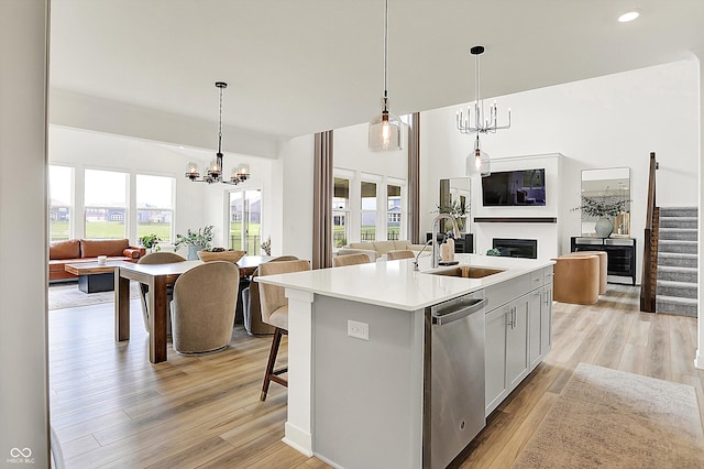 4250 Blackford Rd, Bargersville, IN 46106 - kitchen featuring open floor plan, stainless steel dishwasher, a center island with sink, light countertops, and light wood-type flooring