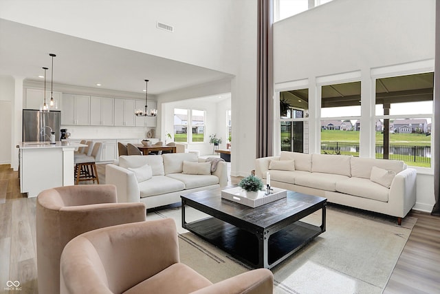 4250 Blackford Rd, Bargersville, IN 46106 - living area featuring a chandelier, light wood finished floors, a towering ceiling, and a water view
