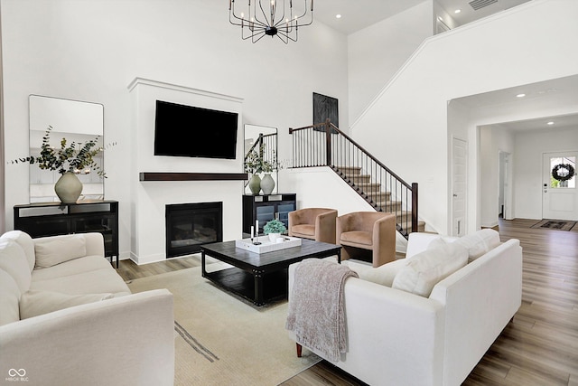 4250 Blackford Rd, Bargersville, IN 46106 - living room with stairs, a high ceiling, wood finished floors, a glass covered fireplace, and recessed lighting