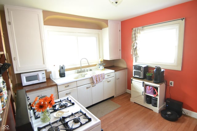 2616 Jackson St, Anderson, IN 46016 - kitchen with white microwave, gas stove, light wood-type flooring, and plenty of natural light