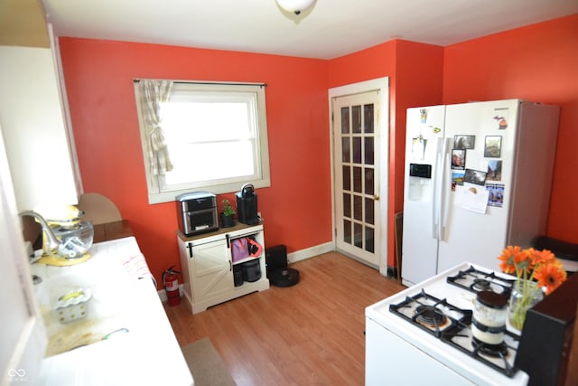 2616 Jackson St, Anderson, IN 46016 - kitchen featuring white appliances, light wood-style floors, and light countertops