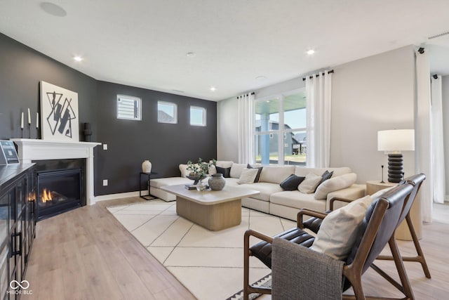 6842 Jacone Dr, Brownsburg, IN 46112 - living area featuring light wood-style floors, plenty of natural light, a glass covered fireplace, and recessed lighting