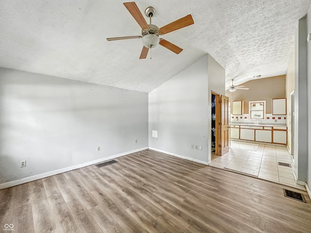 3251 Mars Hill St, Indianapolis, IN 46221 - unfurnished living room with a ceiling fan, a textured ceiling, lofted ceiling, and light wood-style flooring