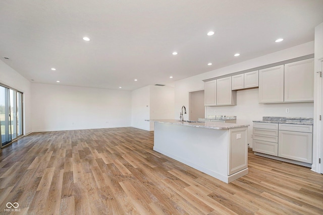 202 Asbury Dr, Anderson, IN 46013 - kitchen with light wood finished floors, a center island with sink, light stone countertops, open floor plan, and recessed lighting