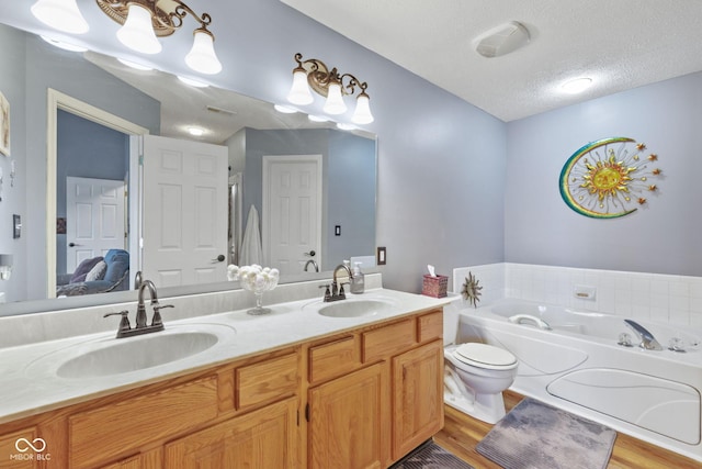 1896 Central Park Blvd W, Greenwood, IN 46143 - ensuite bathroom with a bath, double vanity, wood finished floors, and a textured ceiling