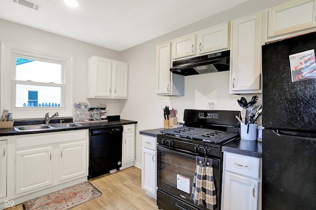 818 Vasbinder Dr, Chesterfield, IN 46017 - kitchen with black appliances, under cabinet range hood, dark countertops, light wood-style floors, and white cabinets
