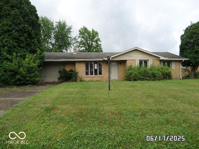 311 Fall Creek Dr, Anderson, IN 46013 - ranch-style home featuring a front yard, a chimney, and brick siding