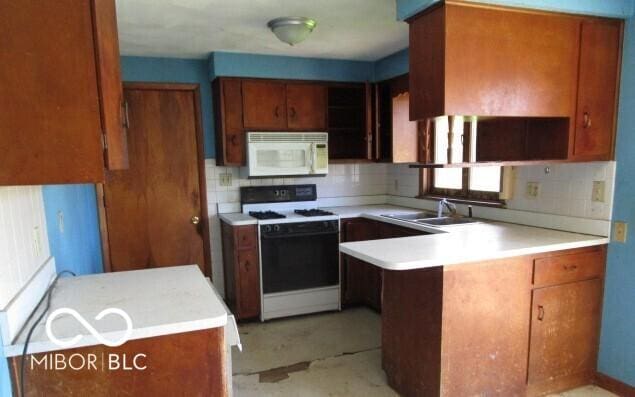 311 Fall Creek Dr, Anderson, IN 46013 - kitchen featuring white appliances, a peninsula, and light countertops