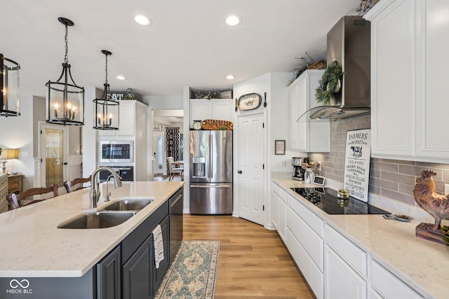 19281 Scofield Ridge Blvd, Westfield, IN 46074 - kitchen with stainless steel appliances, wall chimney range hood, white cabinetry, hanging light fixtures, and a kitchen island with sink