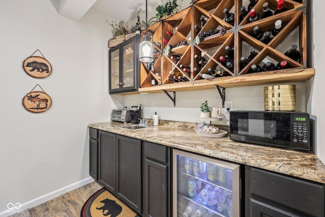 19281 Scofield Ridge Blvd, Westfield, IN 46074 - indoor wet bar with black microwave, wood finished floors, and beverage cooler