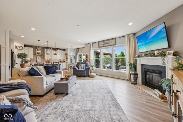 19281 Scofield Ridge Blvd, Westfield, IN 46074 - living area with light wood finished floors, recessed lighting, and a glass covered fireplace