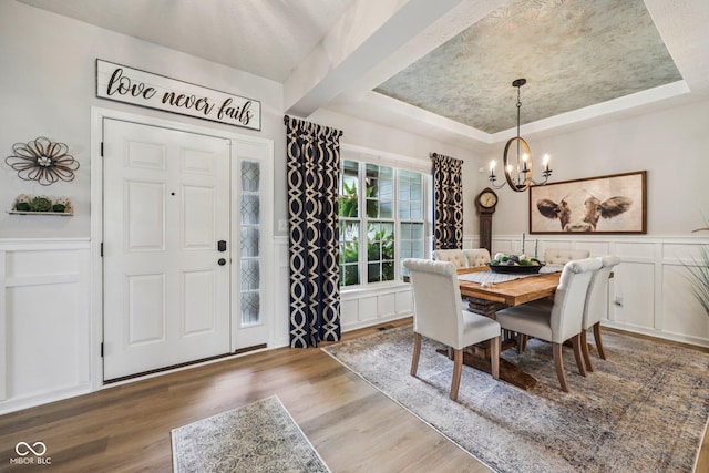 19281 Scofield Ridge Blvd, Westfield, IN 46074 - dining area with a tray ceiling, a decorative wall, a chandelier, wood finished floors, and wainscoting