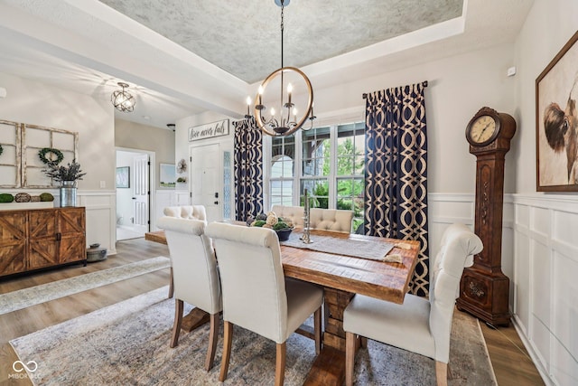 19281 Scofield Ridge Blvd, Westfield, IN 46074 - dining room featuring a chandelier, a decorative wall, wood finished floors, a tray ceiling, and a wainscoted wall