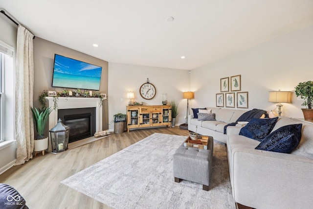 19281 Scofield Ridge Blvd, Westfield, IN 46074 - living room with wood finished floors, a glass covered fireplace, plenty of natural light, and recessed lighting