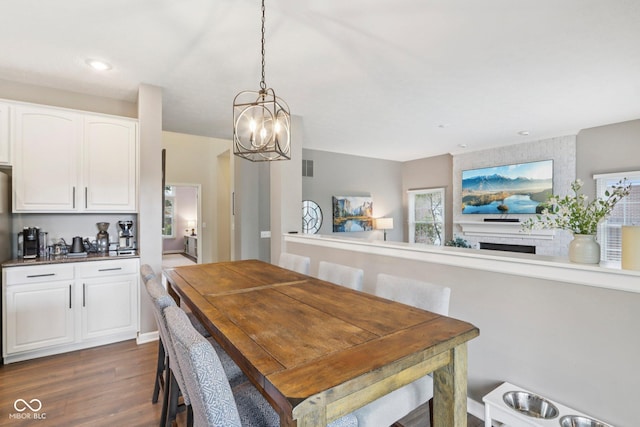 427 Quincy Pl, Westfield, IN 46074 - dining area featuring dark wood finished floors, a chandelier, a brick fireplace, and recessed lighting