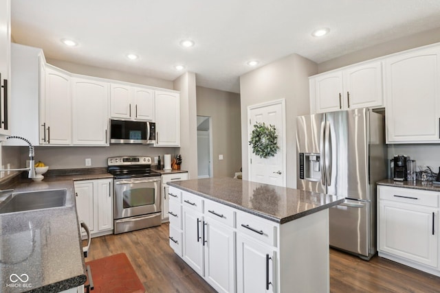 427 Quincy Pl, Westfield, IN 46074 - kitchen featuring appliances with stainless steel finishes, dark wood-style flooring, a center island, white cabinets, and recessed lighting