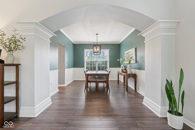 427 Quincy Pl, Westfield, IN 46074 - dining area with crown molding, arched walkways, dark wood finished floors, a chandelier, and decorative columns