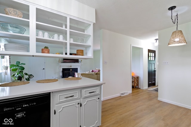 3841 Meridee Dr, Indianapolis, IN 46237 - kitchen featuring dishwasher, light wood-style flooring, a glass covered fireplace, pendant lighting, and white cabinets