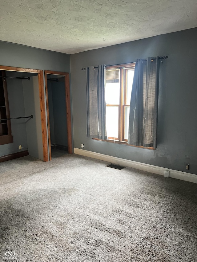 2244 Lafayette St, Anderson, IN 46012 - unfurnished bedroom featuring carpet flooring, two closets, and a textured ceiling