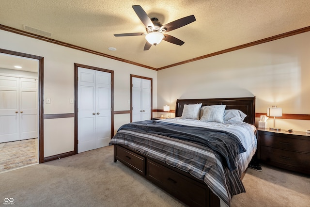 4443 Mallard Pt, Columbus, IN 47201 - bedroom with light colored carpet, multiple closets, a textured ceiling, ceiling fan, and ornamental molding