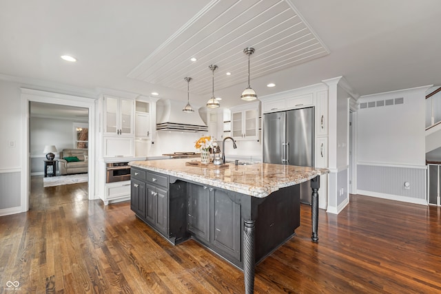 4443 Mallard Pt, Columbus, IN 47201 - kitchen with appliances with stainless steel finishes, range hood, white cabinets, a center island with sink, and recessed lighting