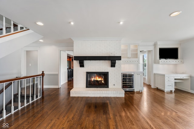 4443 Mallard Pt, Columbus, IN 47201 - unfurnished living room featuring beverage cooler, wood finished floors, crown molding, recessed lighting, and a brick fireplace