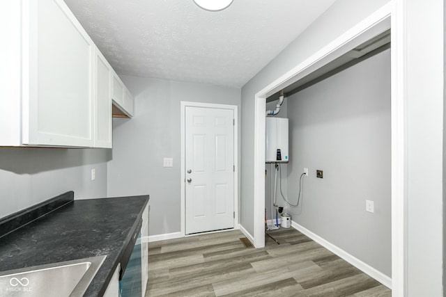 2413 Fowler St, Anderson, IN 46012 - laundry area with light wood-style flooring, water heater, and a textured ceiling