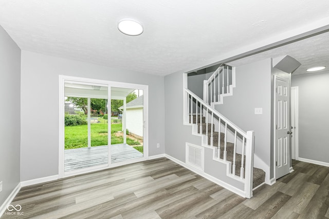 2413 Fowler St, Anderson, IN 46012 - unfurnished room with wood finished floors, stairway, and a textured ceiling