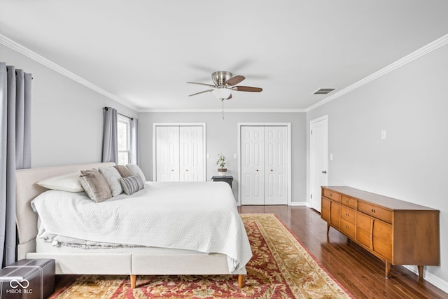 7629 Candlewood Ln, Indianapolis, IN 46250 - bedroom with multiple closets, dark wood-style flooring, ornamental molding, and ceiling fan