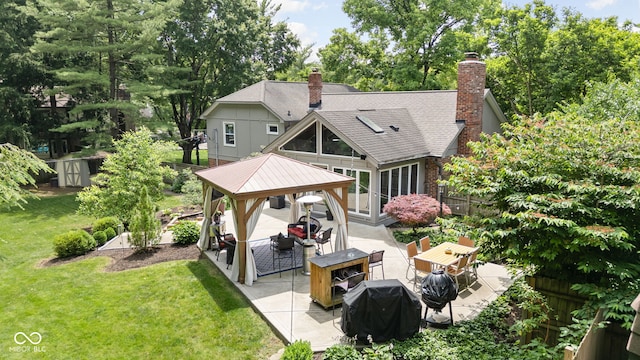7629 Candlewood Ln, Indianapolis, IN 46250 - back of property with a gazebo, a patio, a lawn, a chimney, and roof with shingles