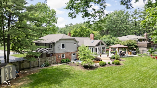 7629 Candlewood Ln, Indianapolis, IN 46250 - rear view of property featuring a gazebo, brick siding, a chimney, a patio, and an outbuilding