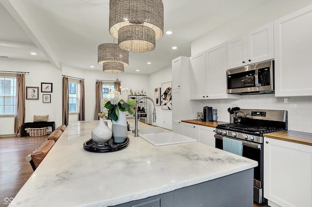 1046 N Hamilton Ave, Indianapolis, IN 46201 - kitchen featuring appliances with stainless steel finishes, a chandelier, white cabinets, plenty of natural light, and recessed lighting