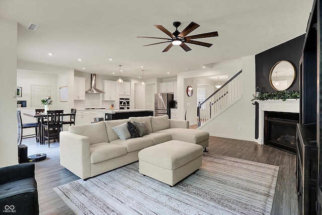5306 Lavender Dr, Plainfield, IN 46168 - living room featuring ceiling fan, stairway, wood finished floors, a glass covered fireplace, and recessed lighting