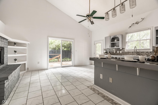 1515 Randall Rd, Indianapolis, IN 46240 - kitchen with open shelves, dark countertops, high vaulted ceiling, a fireplace with raised hearth, and ceiling fan