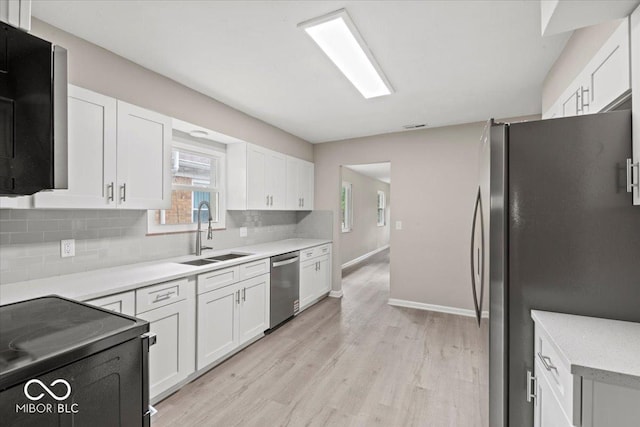 508 W 38th St, Indianapolis, IN 46208 - kitchen featuring stainless steel appliances, backsplash, light wood finished floors, and white cabinets
