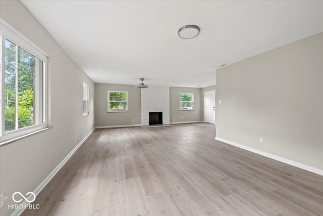 508 W 38th St, Indianapolis, IN 46208 - unfurnished living room with wood finished floors and a brick fireplace