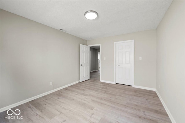 508 W 38th St, Indianapolis, IN 46208 - unfurnished bedroom featuring light wood-style floors and a textured ceiling