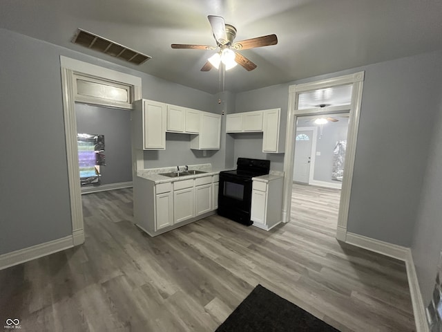 3127 E Lynn St, Anderson, IN 46016 - kitchen with black electric range oven, a ceiling fan, white cabinets, and light countertops