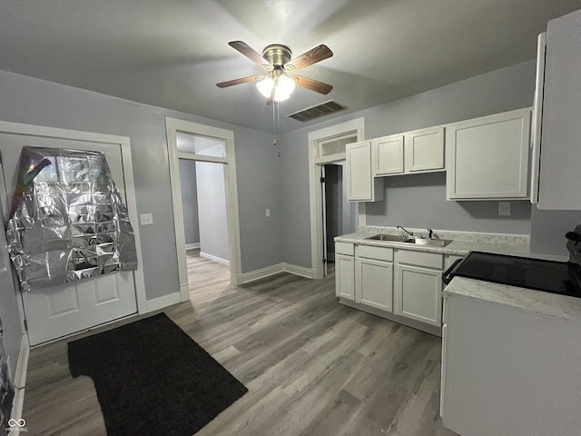 3127 E Lynn St, Anderson, IN 46016 - kitchen with ceiling fan, electric range, white cabinets, and light wood finished floors